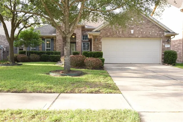 a front view of a house with a yard and potted plants