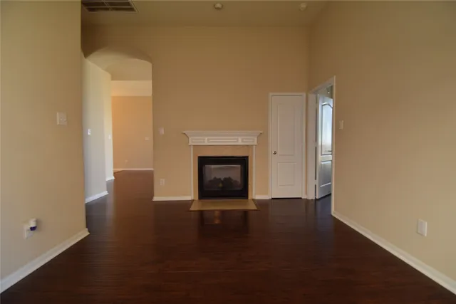 a view of a livingroom with wooden floor and a fireplace
