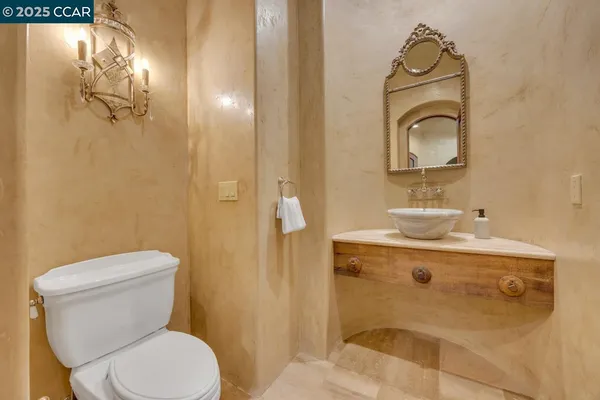 a bathroom with a toilet sink vanity and mirror
