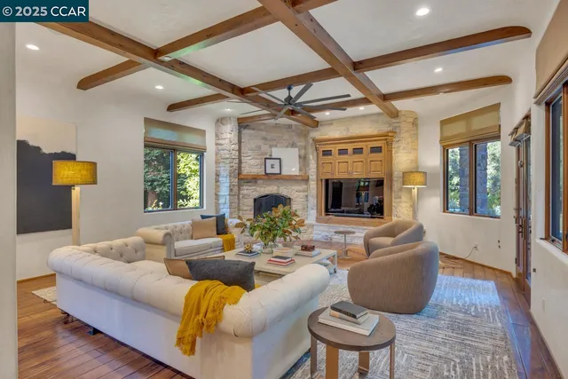 a living room with fireplace furniture and a large window