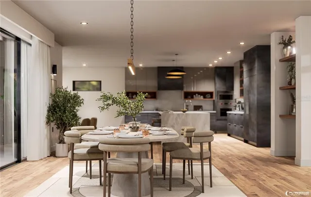 a large kitchen with stainless steel appliances a large counter top and a refrigerator