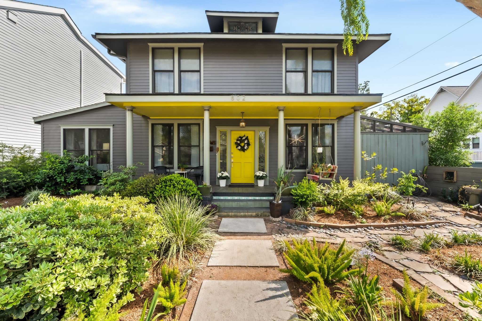 a view of a white house with large windows and a flower garden