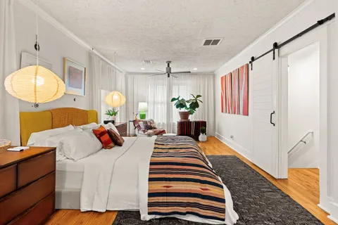 a bedroom with bed and wooden floor