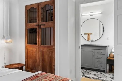 a view of bedroom with a bed and a mirror