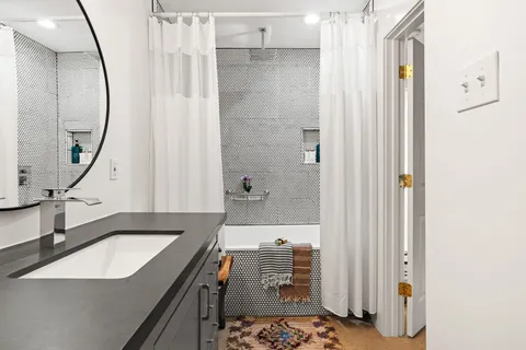 a bathroom with a sink a mirror and a shower