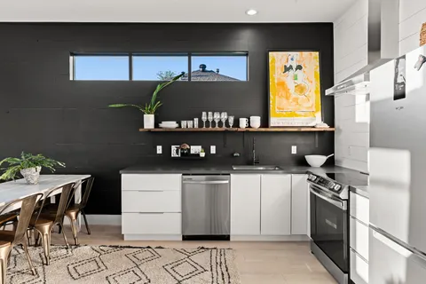a kitchen with stainless steel appliances a stove a sink and a refrigerator