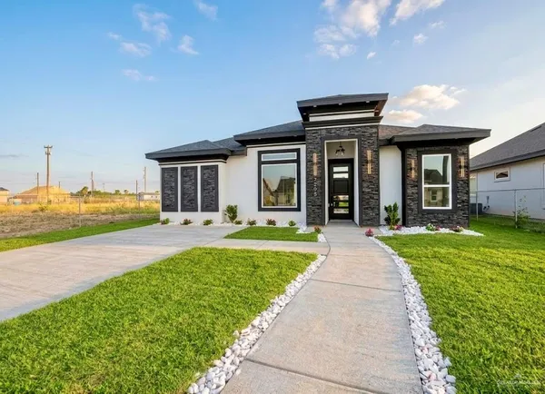 a front view of a house with a yard and porch