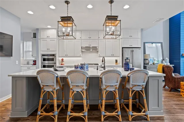 a kitchen with stainless steel appliances a refrigerator sink and cabinets