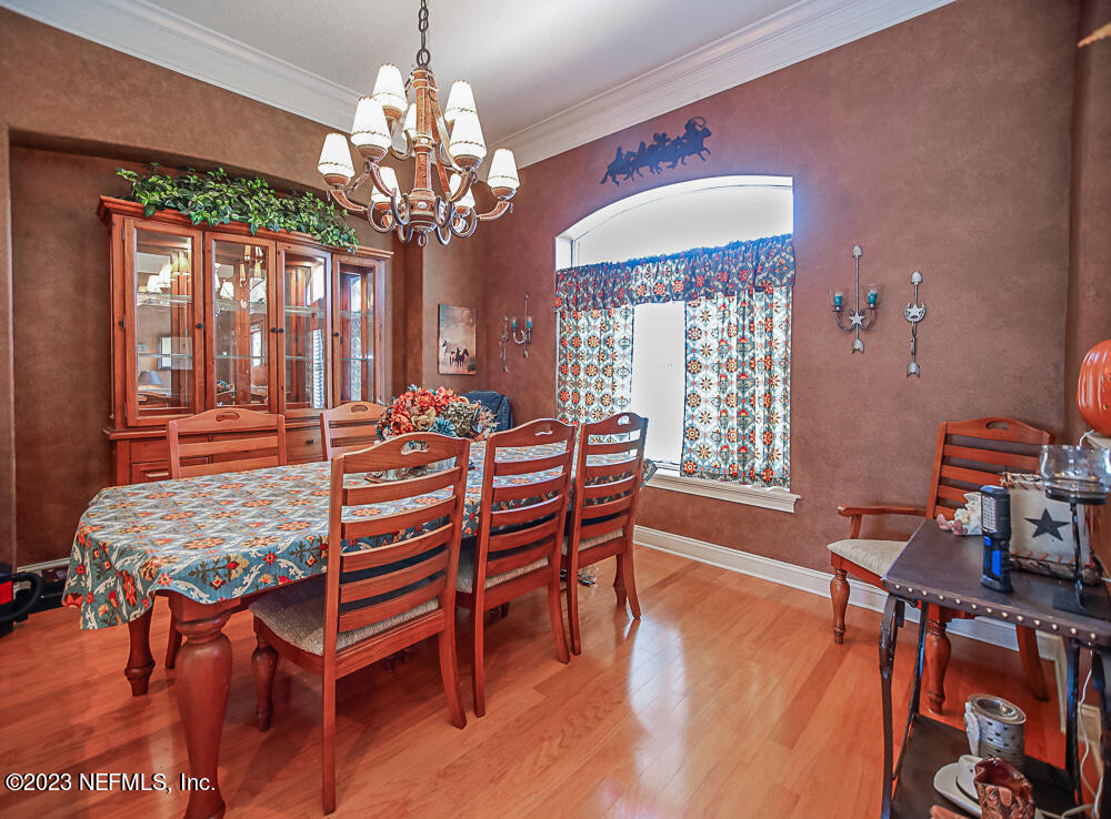 12625 Sawpit Road Jacksonville, FL 32226 - Photo 45 of 63 a dining room with furniture a chandelier and wooden floor
