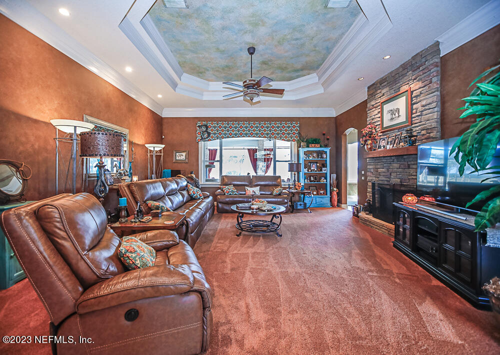 12625 Sawpit Road Jacksonville, FL 32226 - Photo 47 of 63 a living room with furniture a fireplace and a chandelier