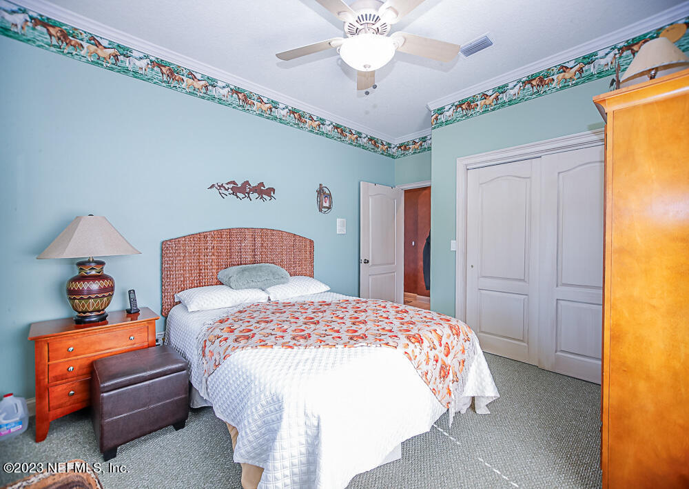 12625 Sawpit Road Jacksonville, FL 32226 - Photo 50 of 63 a bedroom with a bed and a chandelier