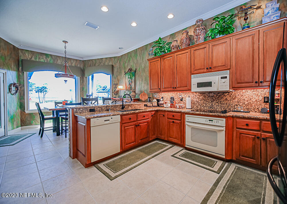 12625 Sawpit Road Jacksonville, FL 32226 - Photo 53 of 63 a kitchen with granite countertop a sink stove and cabinets