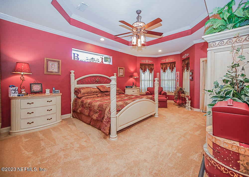 12625 Sawpit Road Jacksonville, FL 32226 - Photo 57 of 63 a bedroom with a bed and a chandelier