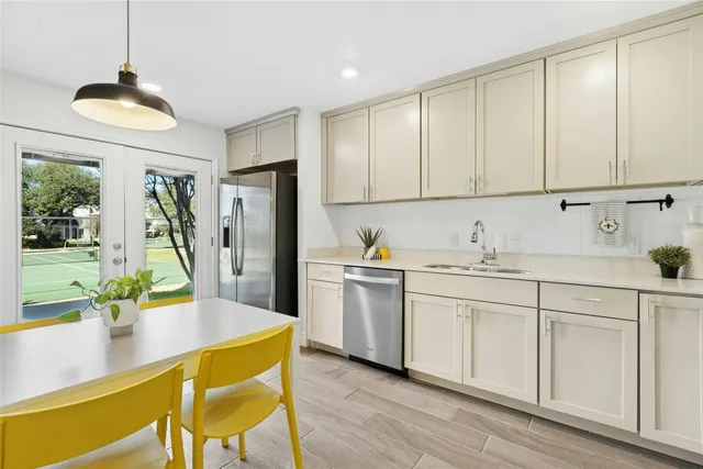a kitchen with stainless steel appliances granite countertop a sink refrigerator and cabinets