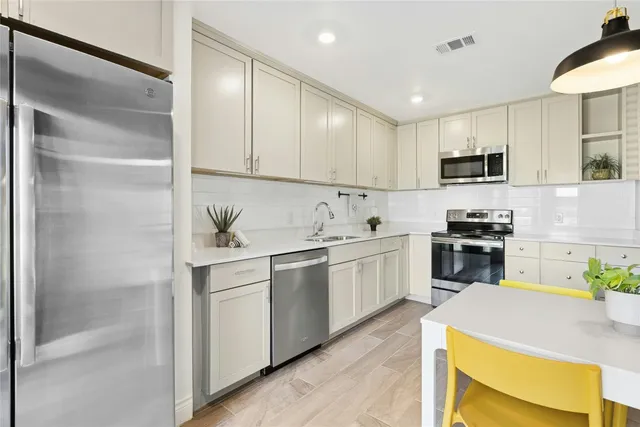 a kitchen with stainless steel appliances granite countertop a sink and a refrigerator