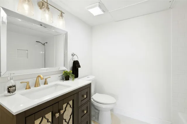 a bathroom with a sink a toilet and mirror