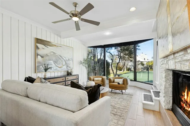 a living room with furniture large windows and a fireplace