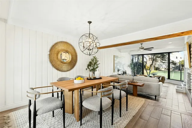 a view of a dining room with furniture large windows and a chandelier