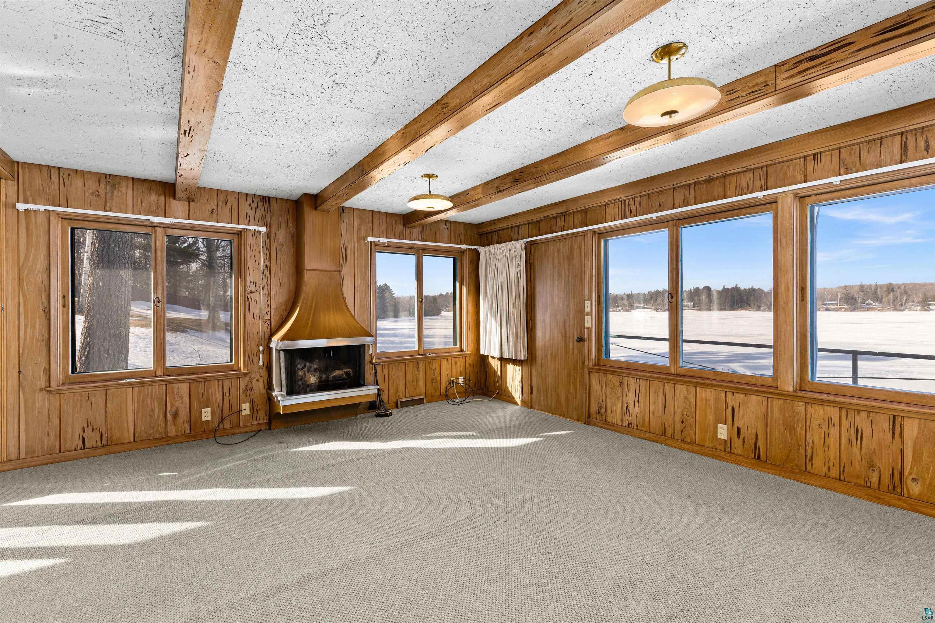 5781 South Pike Lake Road Duluth, MN 55811 - Photo 41 of 42 Unfurnished living room with wood walls, beamed ceiling, and carpet