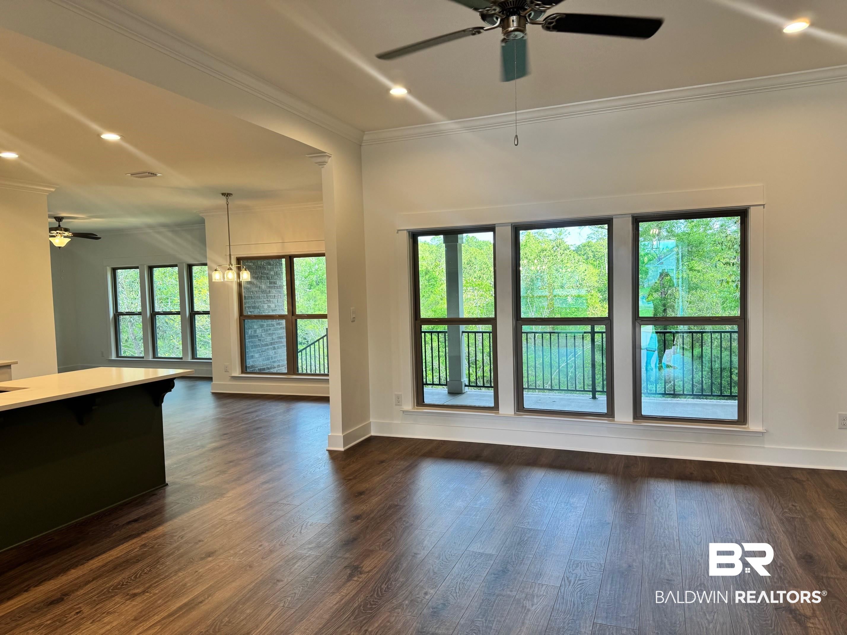 12248 Exbury Way Daphne, AL 36527 - Photo 4 of 63 Unfurnished living room with a ceiling fan, hanging lights, ornamental molding, and dark wood-style floors