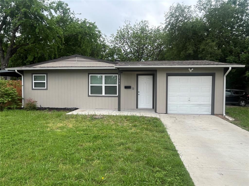 2706 Gross Road Dallas, TX 75228 - Photo 1 of 23 The property features a concrete driveway leading to an attached garage, a front lawn, and a light-colored exterior with white-framed windows