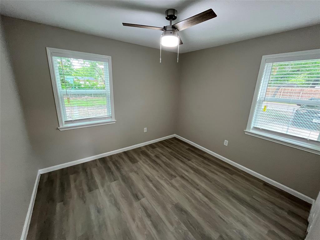 2706 Gross Road Dallas, TX 75228 - Photo 11 of 23 This room features two windows with blinds, a ceiling fan with integrated lighting, and wood-look flooring