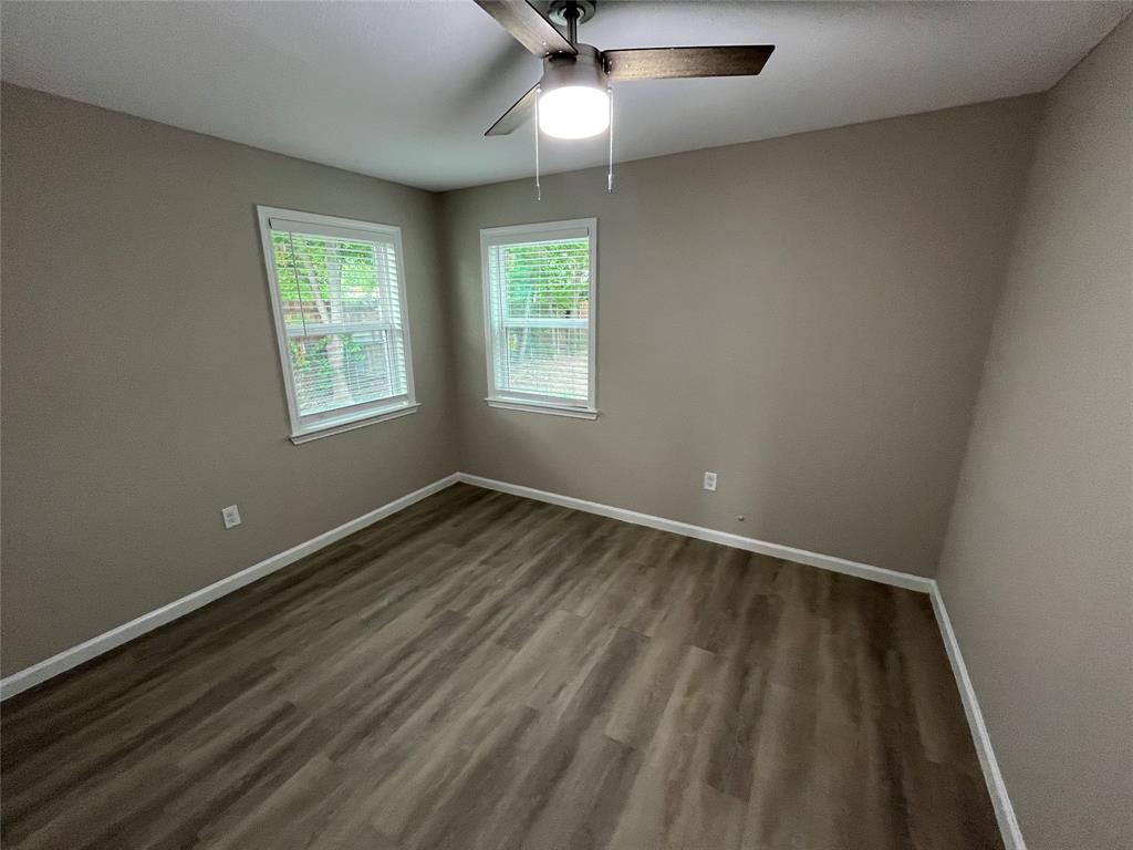 2706 Gross Road Dallas, TX 75228 - Photo 13 of 23 This room features neutral-toned walls, two windows with blinds, and wood-look flooring