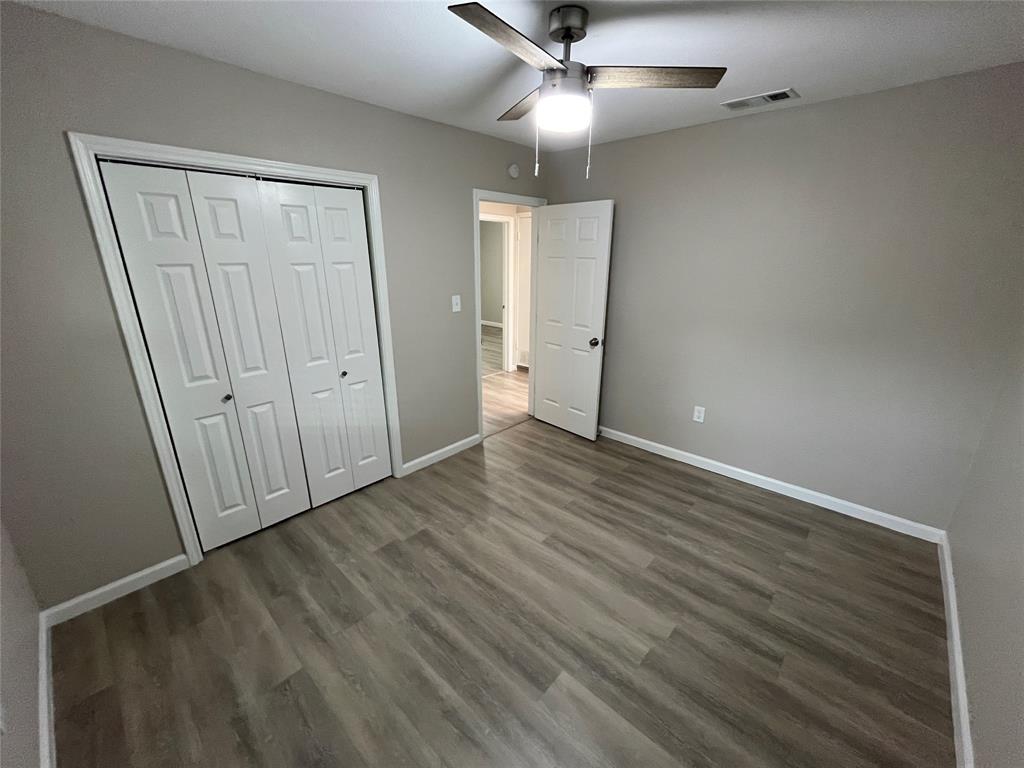 2706 Gross Road Dallas, TX 75228 - Photo 16 of 23 This room features wood-look flooring, light grey walls, and a ceiling fan with integrated lighting
