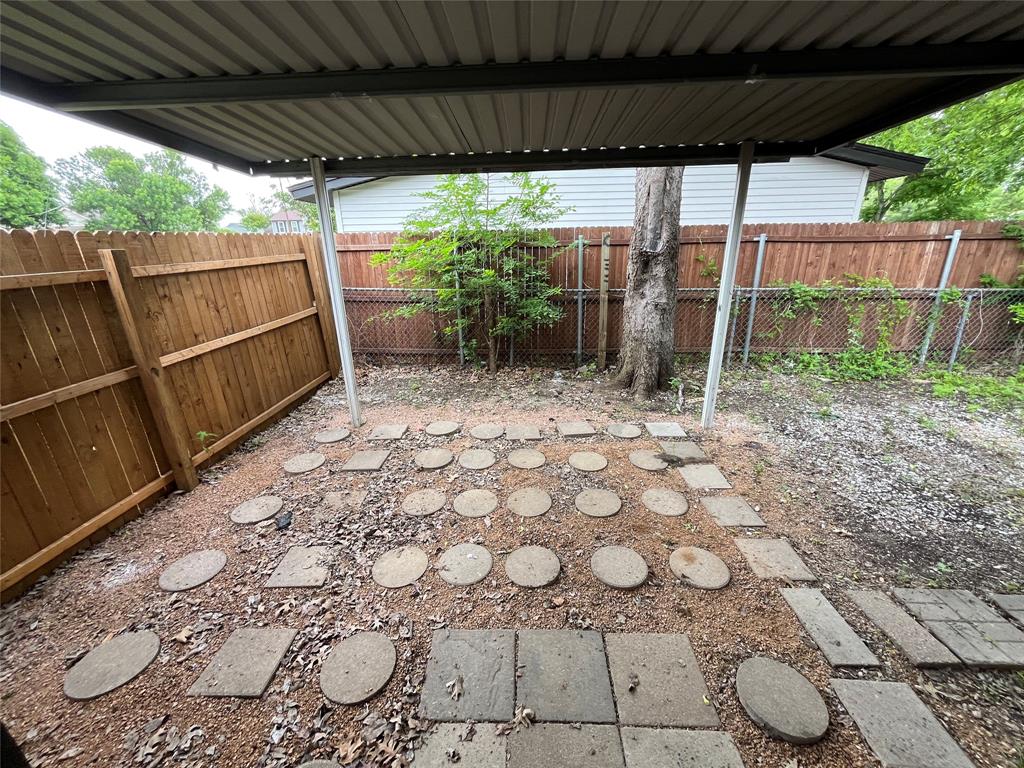 2706 Gross Road Dallas, TX 75228 - Photo 17 of 23 The property features a covered patio area with a concrete slab roof, supported by metal posts