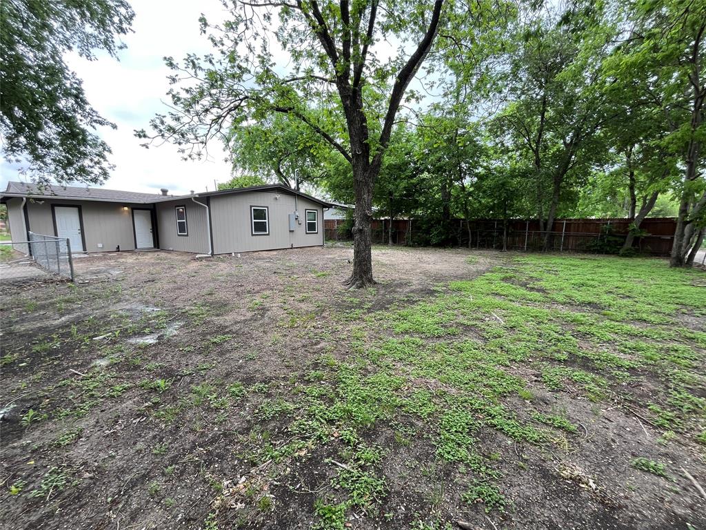 2706 Gross Road Dallas, TX 75228 - Photo 20 of 23 The property features an extensive yard with a tree and a wooden fence along the perimeter