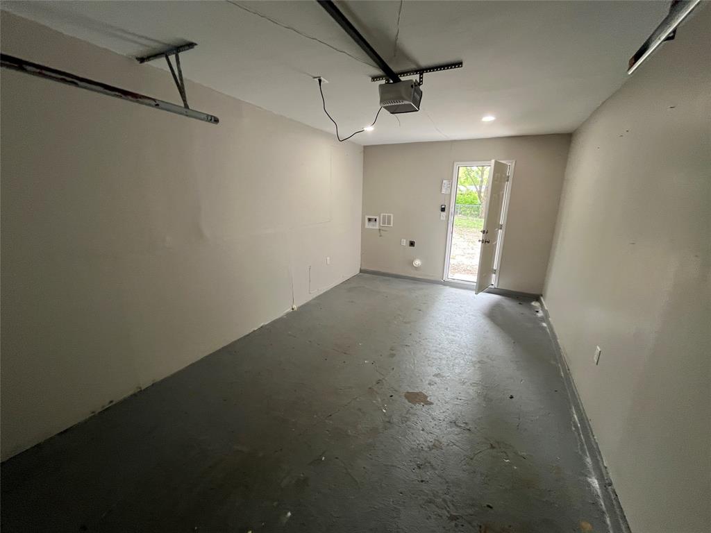 2706 Gross Road Dallas, TX 75228 - Photo 22 of 23 The property includes a garage with a concrete floor, an overhead door track, and an exterior door providing additional access