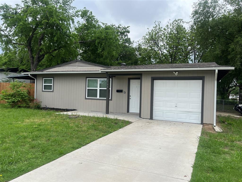 2706 Gross Road Dallas, TX 75228 - Photo 3 of 23 The property features a neutral-toned exterior with a white garage door and a concrete driveway