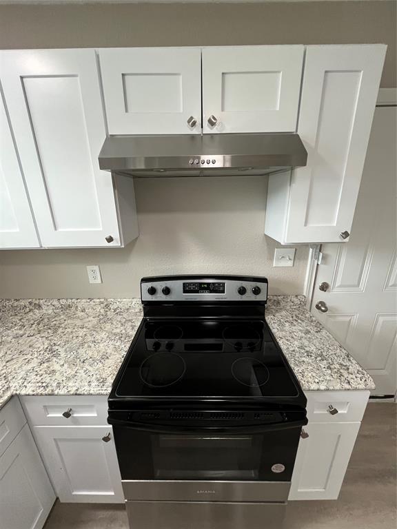 2706 Gross Road Dallas, TX 75228 - Photo 9 of 23 The kitchen features white shaker-style cabinetry, granite-style countertops, and a stainless steel range hood
