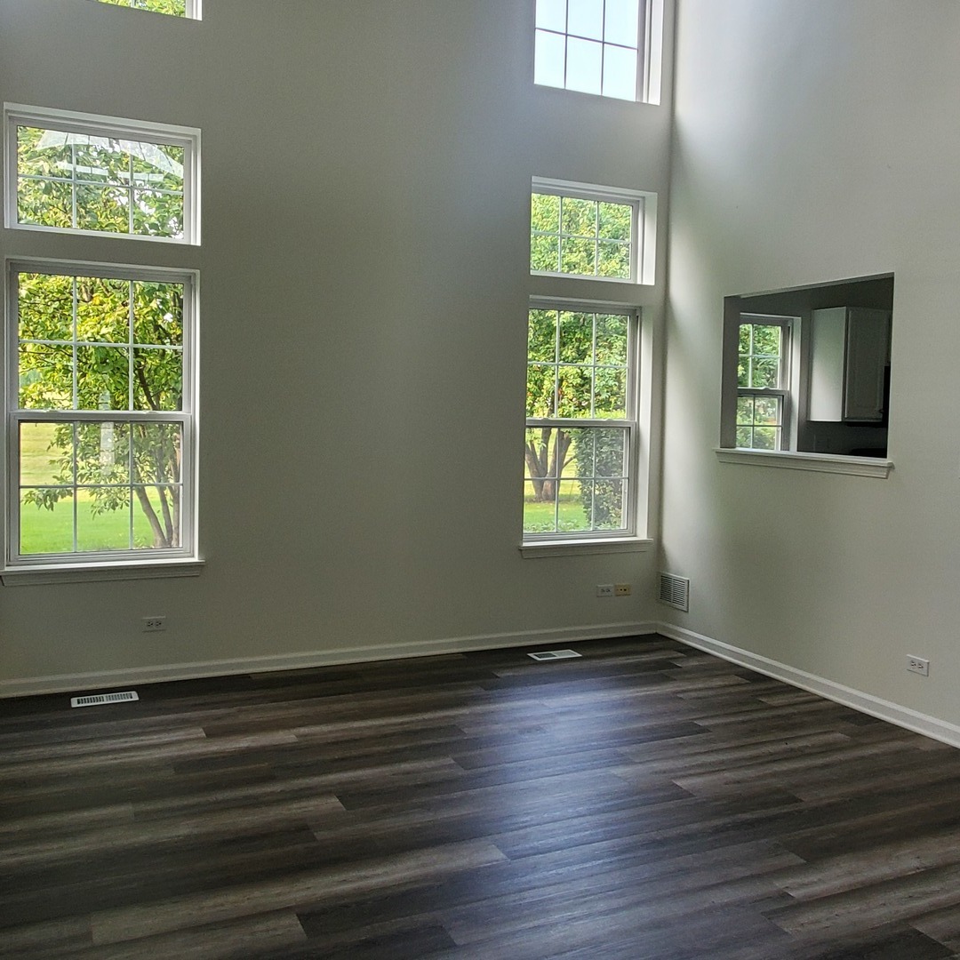 644 Lancaster Drive Pingree Grove, IL 60140 - Photo 10 of 21 a view of an empty room with wooden floor and a window