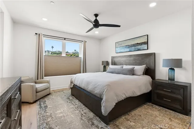 a bedroom with a bed couches and flat screen tv