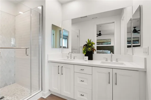 a bathroom with a double vanity sink mirror and shower