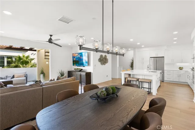 a living room with furniture kitchen view and a wooden floor