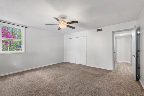 a view of room with a ceiling fan and a window