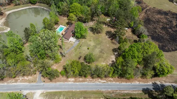 an aerial view of residential house with yard and swimming pool