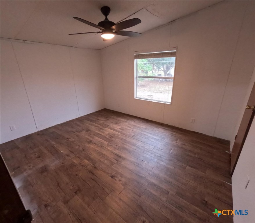 590 Lee Street Victoria, TX 77905 - Photo 12 of 41 an empty room with wooden floor ceiling fan and windows