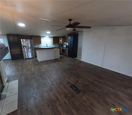 a view of a room wooden floor fireplace and windows