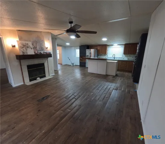 an empty room with wooden floor chandelier and windows