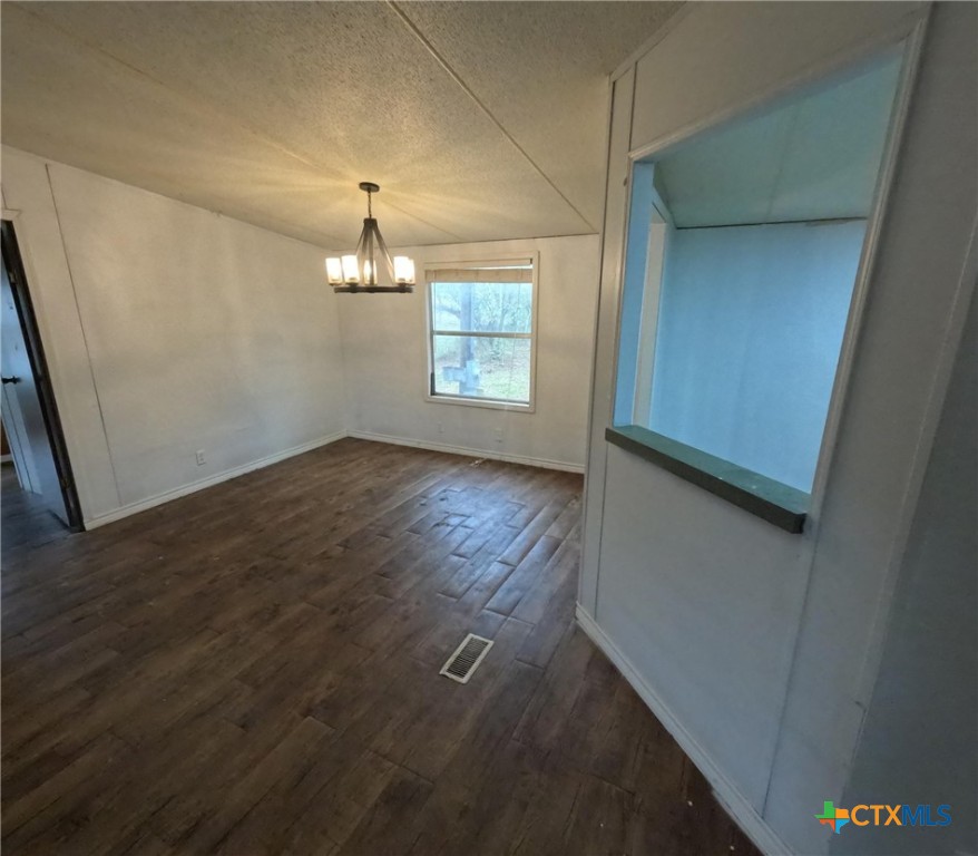 590 Lee Street Victoria, TX 77905 - Photo 24 of 41 an empty room with wooden floor chandelier and windows