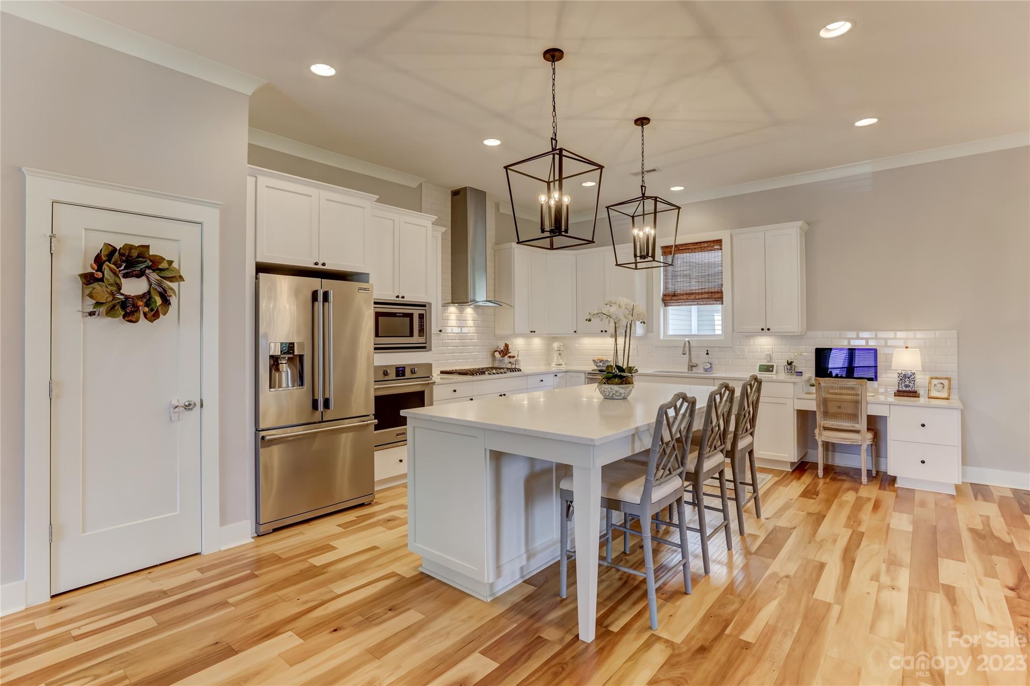 151 Inspired Way Fort Mill, SC 29708 - Photo 11 of 48 a kitchen with stainless steel appliances kitchen island granite countertop a refrigerator a stove top oven a dining table and chairs with wooden floor