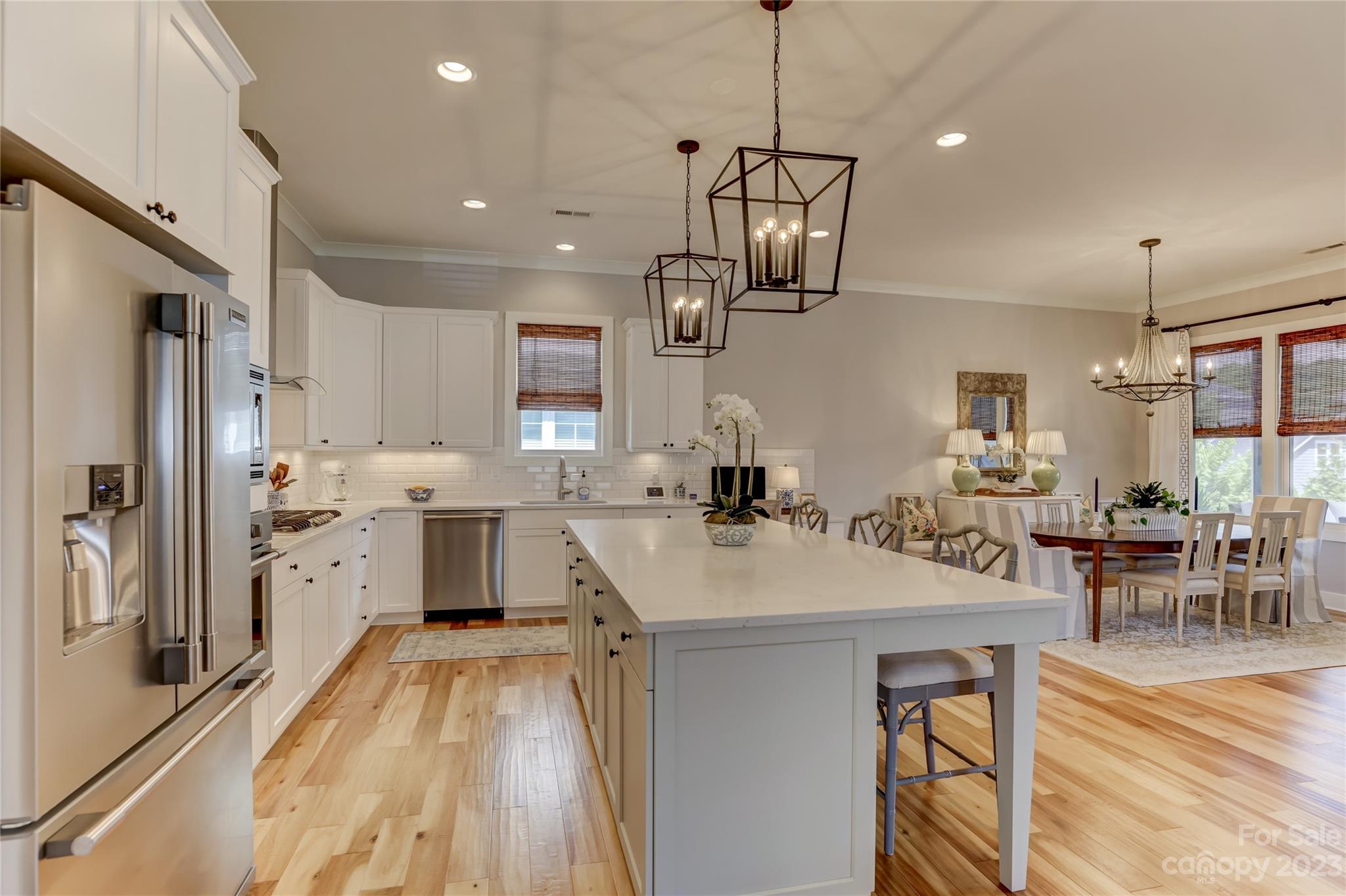 151 Inspired Way Fort Mill, SC 29708 - Photo 12 of 48 a open kitchen with stainless steel appliances granite countertop a sink dishwasher a refrigerator a stove a dining table and chairs with wooden floor