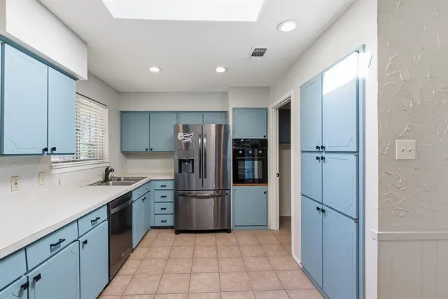 a kitchen with refrigerator and cabinets