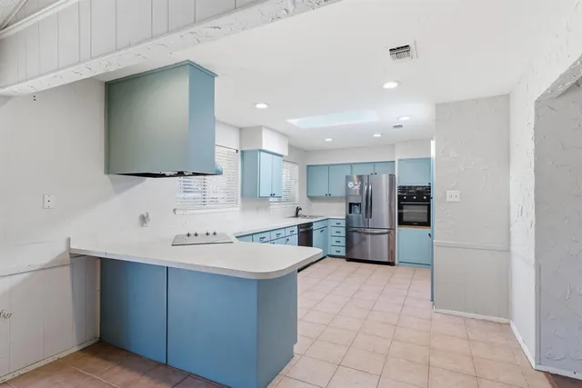 a large kitchen with stainless steel appliances a sink a counter top space cabinets and a counter top space