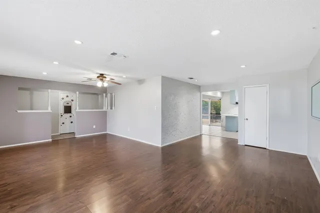 a view of a big room with wooden floor and windows