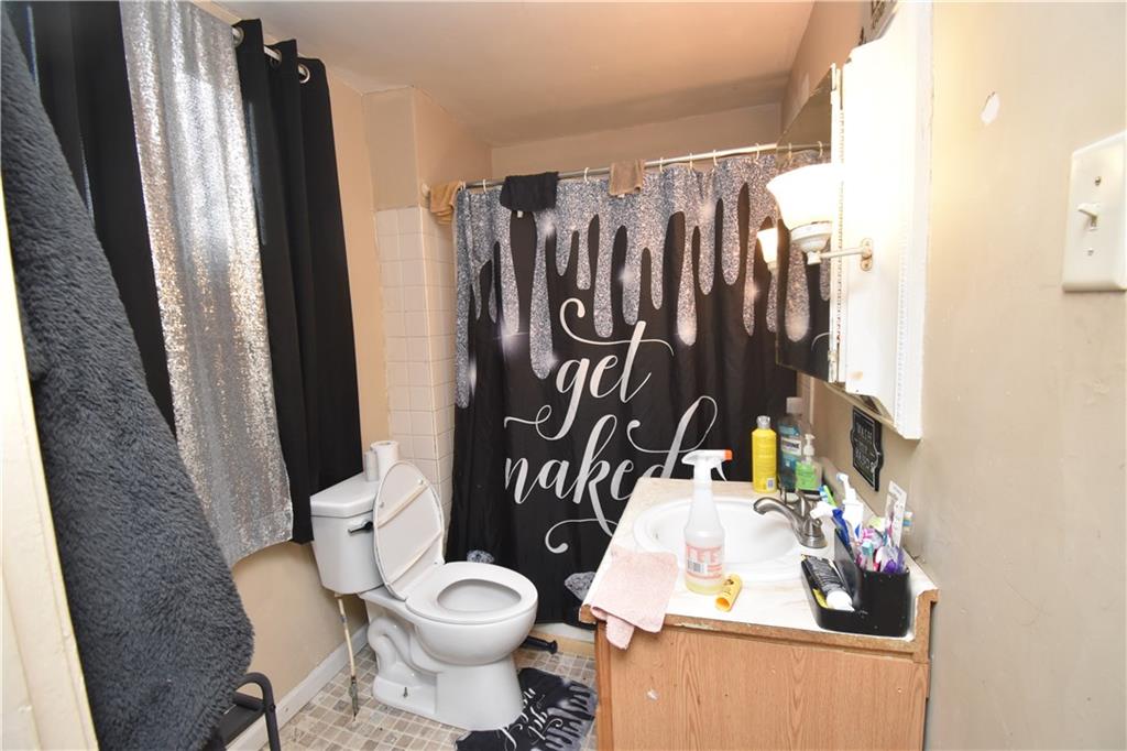 2118 Elsie Street Pittsburgh, PA 15210 - Photo 7 of 12 a bathroom with a toilet sink and shower curtain