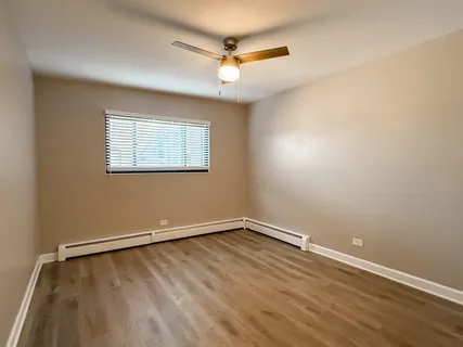an empty room with a window and a ceiling fan